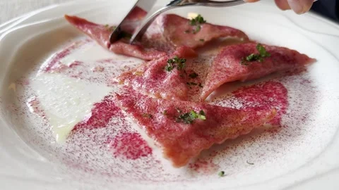 Fork and Knife Cutting Beetroot Ravioli on a White Plate Video stock 269893918