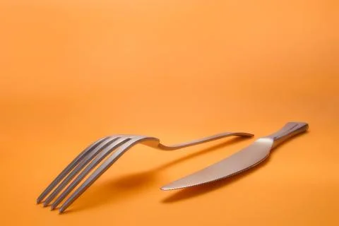Fork and knife on orange background Foto stock