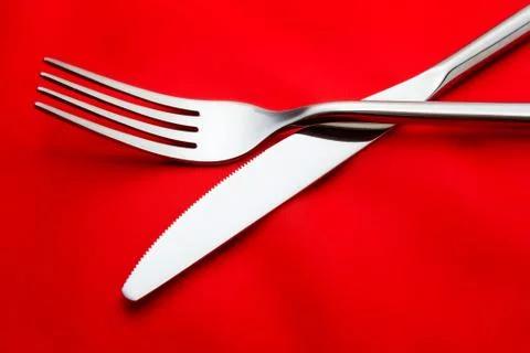 Fork and knife on red background Stock Photos