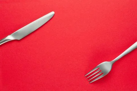 Fork and knife on red background Foto stock