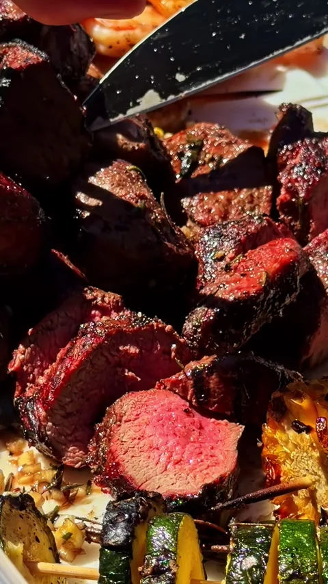 Fork and Knife Slicing Grilled Beef With Charred Vegetables and Corn 動画素材 336781162