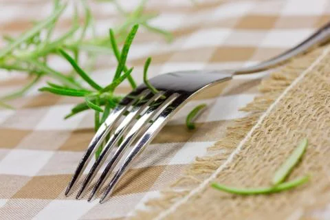 Fork and rosemary on table Stock Photos