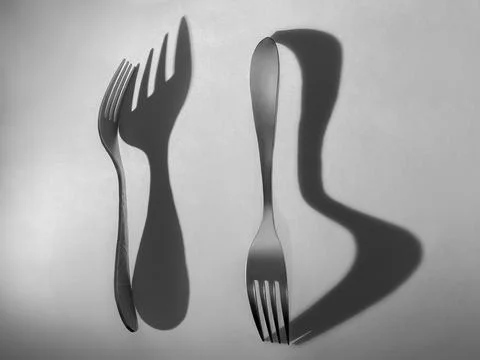 Fork and spoon with abstract shadows in monochrome light Foto stock