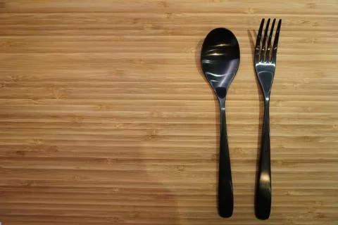 Fork and spoon arrangement on empty table Foto stock