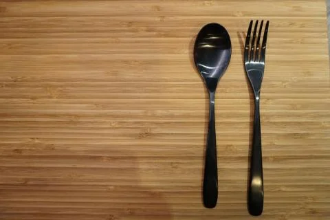 Fork and spoon arrangement on empty table Stock Photos