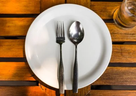 Fork and spoon on white dish Stock Photos