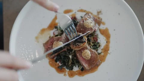 A fork is being used to cut into a plate of food Stock Footage 295994669