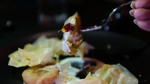 Fork breaking caramelized pear with crispy puff pastry and creamy syrup on black Stock Footage 318383297