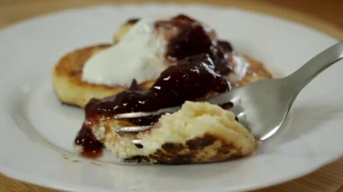 A fork breaks off a piece of cheesecake. Cheesecakes with jam and sour cream. A Stock Footage 315178720