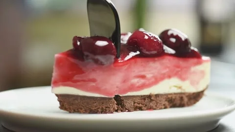 Fork breaks off a piece of no-bake cherry cheesecake. Stock Footage 168146406