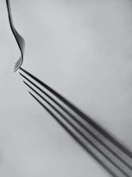 Fork casting long linear shadows creating abstract pattern Stock Photos