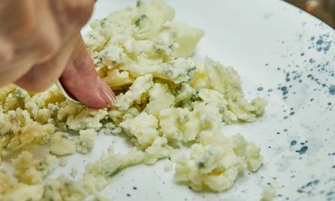 With a fork, the chef kneads mashed potatoes onplate Stock Photos