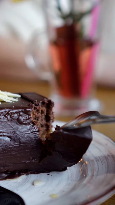 Fork Cuts Into Rich Chocolate Cake Slice On White Ceramic Plate Indoors. Sweet 스톡 동영상 346989518