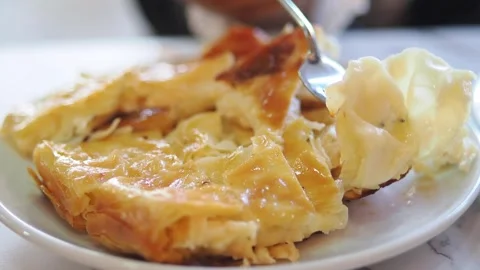 Fork cutting a slice of layered filo pastry on a plate during a meal Stock Footage 348120984