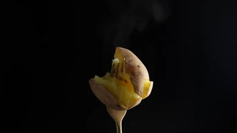 Fork with hot boiled potato on black background, close up, rotates Stock Footage 295140866