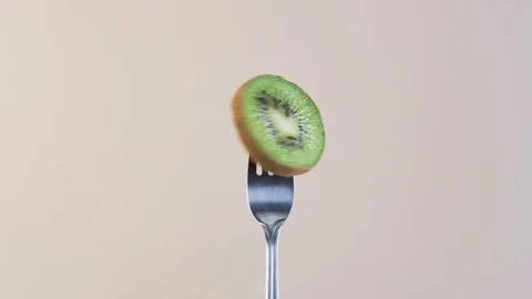 Fork With Kiwi on Almond Background Stock Footage 70535028