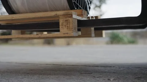 Fork lifter lifting large industrial cable spool secured on a wooden pallet o Stock Footage 319503624