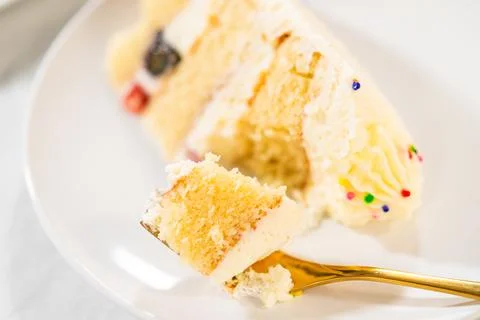 Fork Lifting Bite of Sprinkled Cake Slice Stock Photos