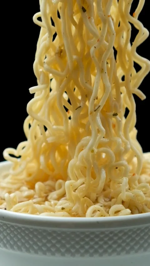 Fork lifting cooked instant ramen noodles from bowl in slow motion in vertical Stock Footage 346604677