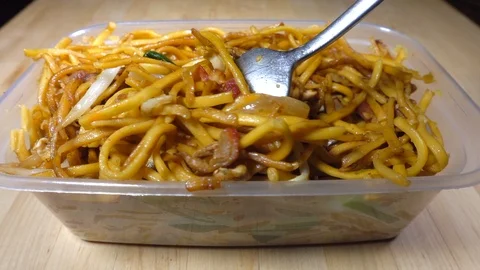 Fork lifting some takeout / takeaway soft noodles from a container. Video stock 114369788