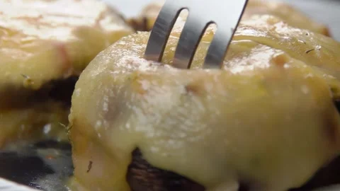 A fork lifts a piece of baked stuffed champignon Stock Footage 296581653