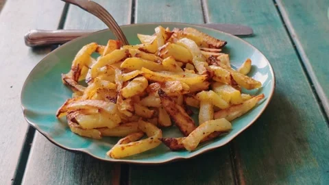 Fork lifts a piece of crispy fried potato from a plate. Vídeo Stock 340926500