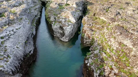 Fork of a narrow mountain river flowing through rocky landscape Stock Footage 133169358