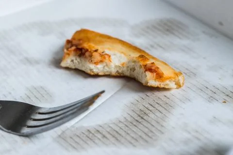 Fork next to a crust of pizza Stock Photos