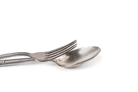 A fork over a spoon on awhite background with copy space Stock Photos