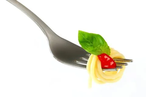 Fork with pasta garnished by basil and cherry tomato Stock Photos