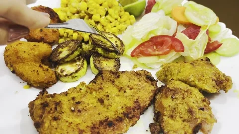 Fork picking up grilled zucchini from plate with chicken and salad, close up Stock Footage 345166423