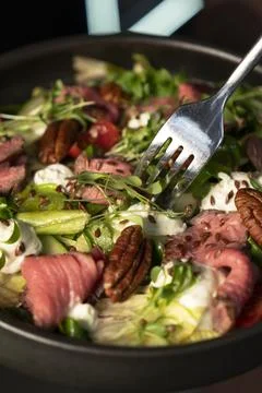 Fork Picking Roast Beef from Fresh Salad Stock Photos