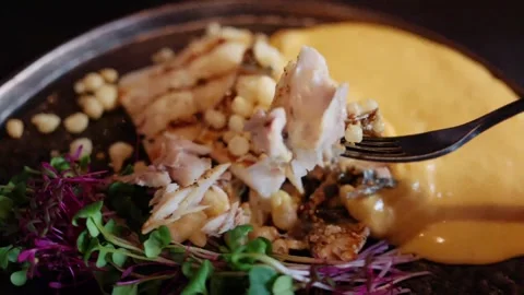 Fork picks up flaked fish with crispy bits and yellow sauce on plate. Vídeos de archivo 339660005