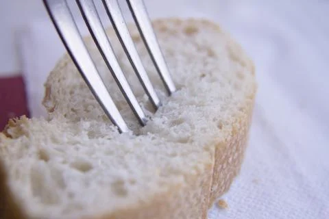 Fork pricking a piece of bread Stock Photos