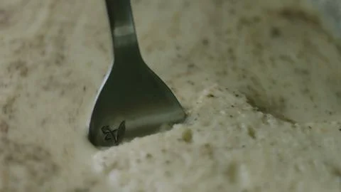 Fork resting in thick spiced custard at close range Stock Photos