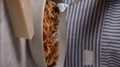 Fork rolling spaghetti. Parmesan on the table. Red tomato spaghetti with cheese. Stock Footage 230421637