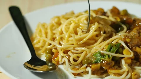 Fork scoop spaghetti over plate on wooden table. Stock Footage 50029957