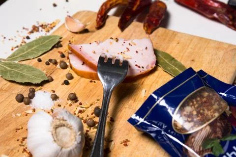Fork with a slice of bacon on board herbs Stock-Fotos