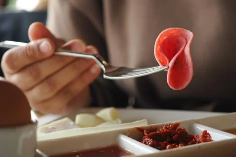 A fork slices of cured meat. Foto stock