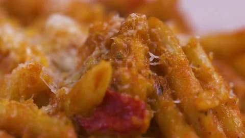 A fork slowly captures a piece of penne pasta in red sauce in slow motion. Stock Footage 72538253