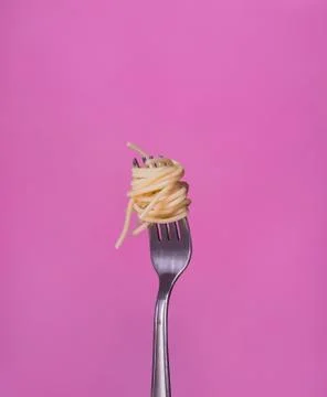 Fork with spaghetti on a pink background Stock Photos