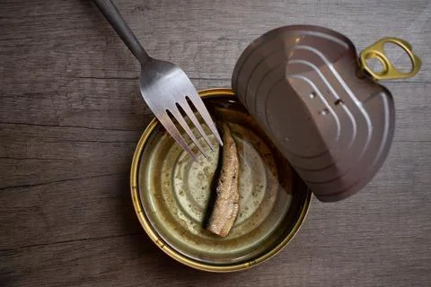 Fork on sprat can with only one depresive sprat in can. Stock Photos