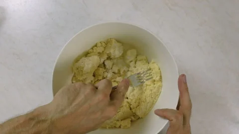 With a fork, stir in just enough water to bind the dough Stock Footage 98457967