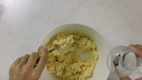 With a fork, stir in just enough water to bind the dough Stock Footage 98458195