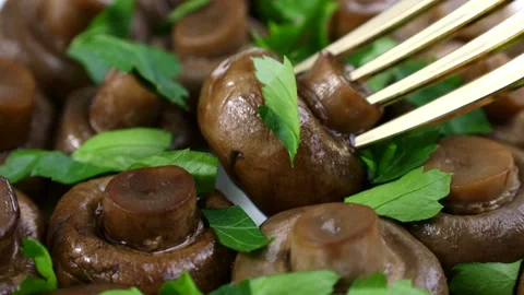 Fork taking brown cooked fried champignon mushrooms to eat close up Stock Footage 274877063