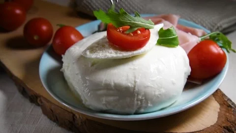 The fork is taking one slice of tomato on a slice of fresh mozzarella Stock Footage 131556756