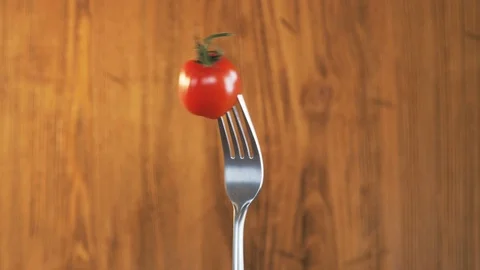 Fork With Tomato on Wooden Background Stock Footage 70535182
