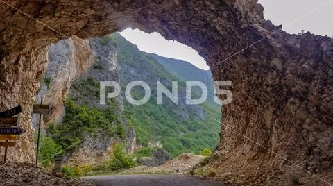 Fork in the tunnel carved into the rock on a mountain road. Country road in t Stock Photos