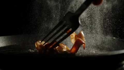 Fork Turning Over A Bacon Slice Frying On A Pan With Splashes Видео 118788304