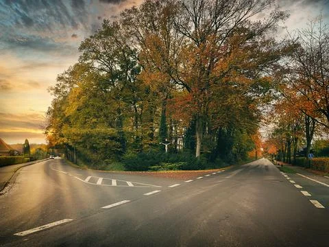 At the fork of two roads during sunset Stock Photos